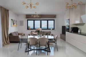 a kitchen and living room with a table and chairs at Villa Palm Bay 1, heated pool - 5 m from the sea in Ražanj