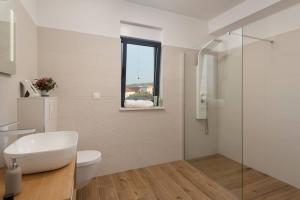 a bathroom with a toilet and a glass shower at Villa Palm Bay 1, heated pool - 5 m from the sea in Ražanj +33 photos