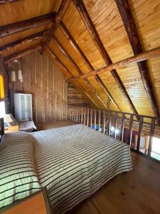 uma cama grande num quarto com tecto em madeira em Cabaña en los soles de montaña em Villa Pehuenia