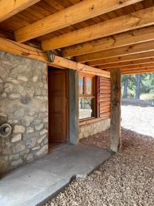 uma vista para o exterior de um chalé com uma porta de madeira em Cabaña en los soles de montaña em Villa Pehuenia