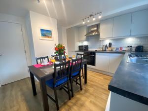 a kitchen with a table and chairs in a kitchen at Cambridge Stays Riverside 2BR Flat-Walk to Centre-Parking-Balcony in Cambridge