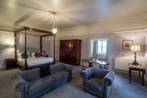 ein Wohnzimmer mit einem Bett, einem Sofa und Stühlen in der Unterkunft Hazlewood Castle & Spa in Tadcaster