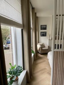 a living room with a couch and a large window at Veldhorst Apartments in Leiden