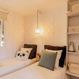 a bedroom with two beds with pillows and a panda face pillow at Camping De Thoissey *** in Thoissey