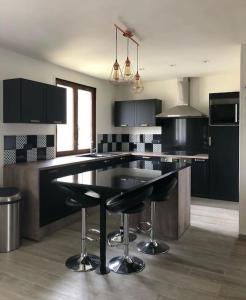 a kitchen with black cabinets and a black counter top at Maison aux Portes de Paris in Vitry-sur-Seine