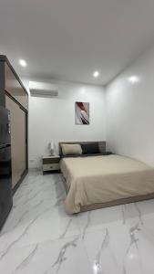 1 dormitorio con 1 cama en una habitación blanca con suelo de mármol en Homestay - Kim Mã - Giang Văn Minh en Hanoi