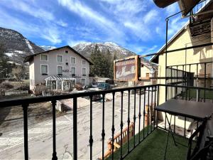 a balcony with a view of a building and mountains at Appartement lumineux 3 pièces – Centre station Serre Chevalier, 4 pers, à 600m des pistes - FR-1-330F-236 in La Salle Les Alpes