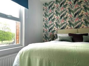 a bedroom with a bed with a floral wallpaper at Spacious 4 Bed House With Park Views in Lincolnshire
