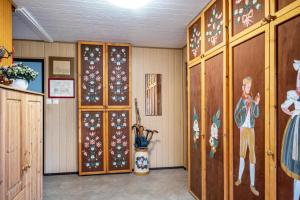 Cette chambre dispose de portes en bois et de peintures sur les murs. dans l'établissement Am Teich, à Bützow