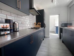 a kitchen with blue cabinets and a counter top at Spacious 4 Bed House With Park Views in Lincolnshire