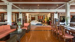 a living room with a couch and tables and chairs at Talay Naiharn Villa in Rawai Beach