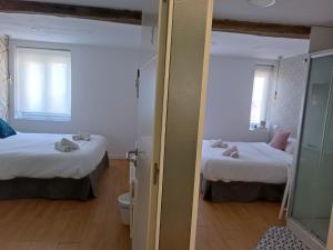 a small room with two beds and a mirror at Rin Rooms in Mutriku