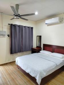 - une chambre avec un grand lit et un ventilateur de plafond dans l'établissement Restu Chalet Tioman, à l'Île Tioman