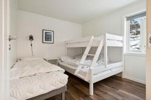 1 dormitorio con 2 literas y ventana en Stor rorbu med hoy standard, en Stamsund