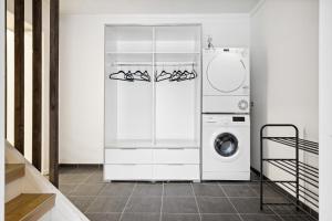 lavadero blanco con lavadora y secadora en Stor rorbu med hoy standard, en Stamsund