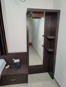 un espejo sentado en la parte superior de un tocador en un dormitorio en Ratna Sagar, en Udupi