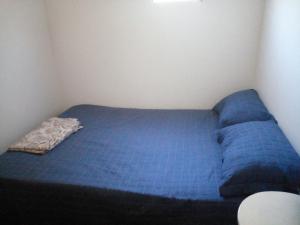 a small blue bed in a small room at mi Habitat in Asunción
