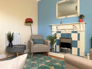 a living room with a chair and a fireplace at Station House - 2bed House Central Location in Lincolnshire