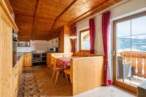a kitchen with a table and a dining room at Malsötscherhof Apt C in Villandro