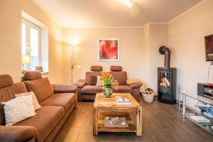 a living room with a couch and a wood stove at Ferienhaus Austernperle, Familie Creutz in Sankt Peter-Ording