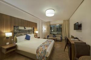 Melliber Appart Hotel في الدار البيضاء: غرفة الفندق بسرير كبير ومكتب