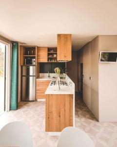 a kitchen with wooden cabinets and a white counter top at Camping Le Braou - Maeva in Audenge +21 photos