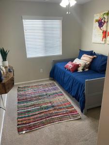 - une chambre avec un lit bleu et un tapis dans l'établissement New beautifully remodeled home in Las Vegas, à Las Vegas