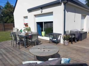 a patio with a table and chairs on a deck at Maison de la croix Marion in Chinon