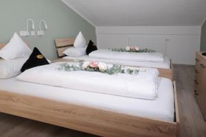 Dos camas en una habitación con flores. en Boardinghouse Schongau, en Schongau