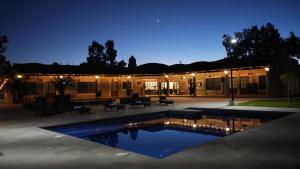 - un grand bâtiment avec une piscine la nuit dans l'établissement Hermosas suites en Hacienda Kuxtal, à Palmillas
