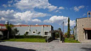 un edificio blanco con un patio y una calle en Hermosas suites en Hacienda Kuxtal, en Palmillas