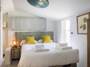 ein Schlafzimmer mit einem großen weißen Bett mit gelben Kissen in der Unterkunft Cathedral Cozy Penthouse in Granada