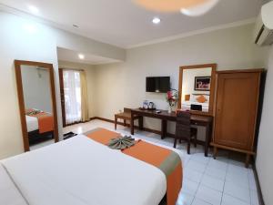 Habitación de hotel con cama y escritorio en Hotel Catur Putra, en Magelang