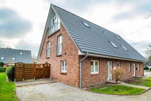 a red brick house with a black roof at Ferienhaus Austernperle, Familie Creutz in Sankt Peter-Ording