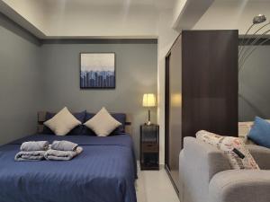 um quarto com uma cama azul com toalhas em Modern Studio in the Centre of Chiang Mai em Chiang Mai