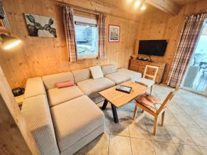 a living room with a couch and a table at Woody Park Chalet 14 in Kaindorf