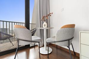 杜拜的住宿－Silkhaus Modern Studio near Silicon Shopping Mall，带阳台的客房内配有两把椅子和一张桌子