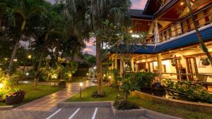 a resort with palm trees and a building at Talay Naiharn Villa in Rawai Beach