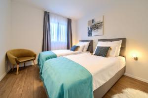 a bedroom with two beds and a chair and a window at Villa Andante in Krk +49 photos