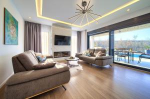 a living room with a couch and chairs and a chandelier at Villa Andante in Krk