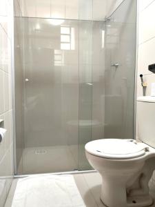 uma casa de banho com um WC e uma cabina de duche em vidro. em Machado´s Plaza Hotel em Belém