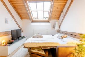 a attic bedroom with a bed and a television at Place of Grace - 50 Meters from Dancing House in Prague