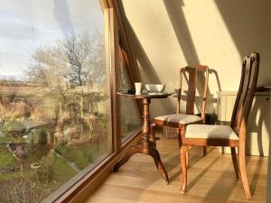 a table and two chairs in front of a window at Luxurious Oak Barn in Cotswold Countryside in Shipston-on-Stour