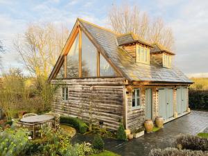 a small log cabin with a table in front of it at Luxurious Oak Barn in Cotswold Countryside in Shipston-on-Stour