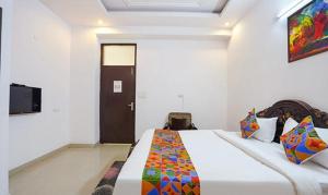 a bedroom with a bed and a television in it at FabHotel Noida Sector 50 in Noida