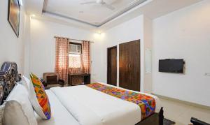 a bedroom with a bed and a flat screen tv at FabHotel Noida Sector 50 in Noida
