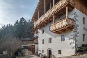 a building with a balcony on the side of it at Malsötscherhof Apt B in Villandro