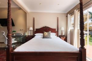 a bedroom with a large bed with a wooden frame at House Falcon - close to ZAH in Pretoria