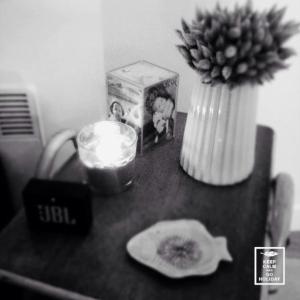 uma mesa com uma vela e um vaso com uma flor em Appartement cosy, vue sur parc, 3 mins plage Benoit em La Baule