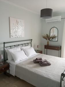 a bedroom with a white bed with two towels on it at SKY AND SEA APARTMENT in Xylokastro